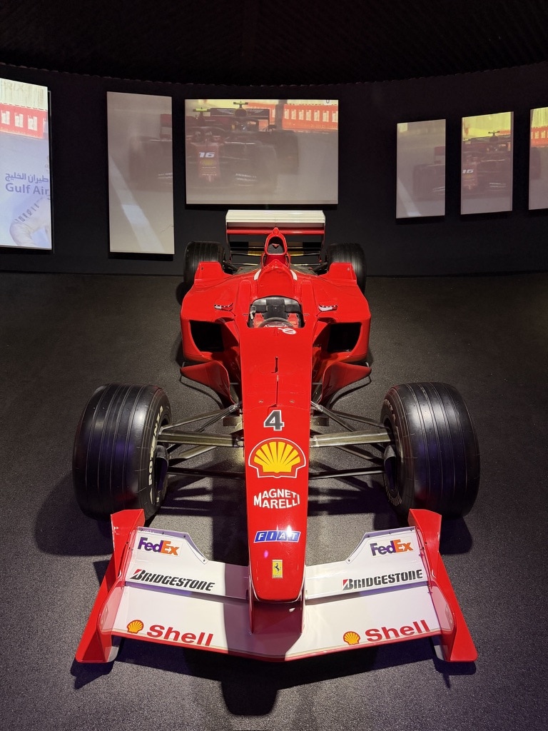 A Ferrari Formula 1 race car with number 4 sits displayed in a museum exhibit